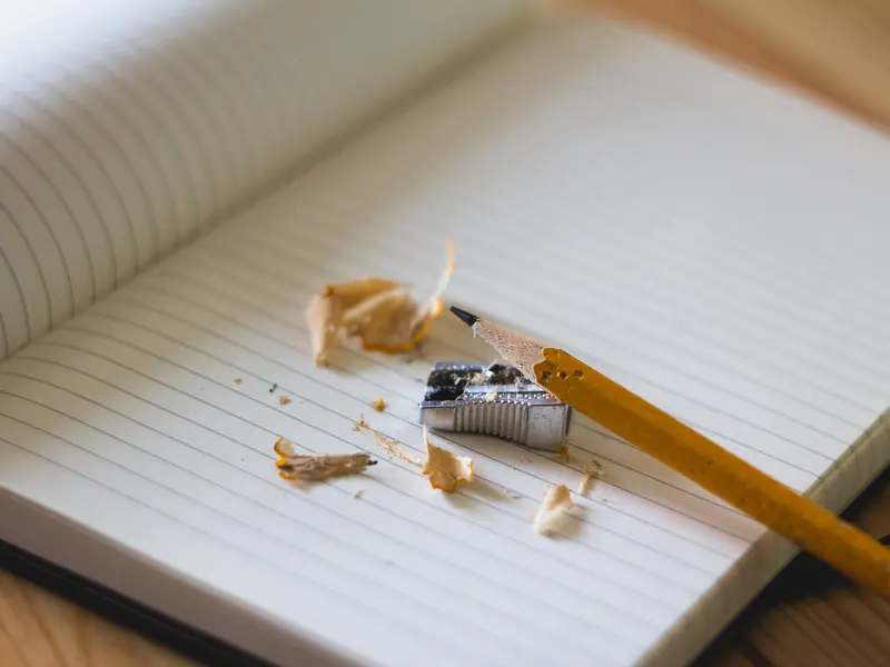 Cahier ouvert avec un crayon et des copeaux de taille-crayon sur un bureau