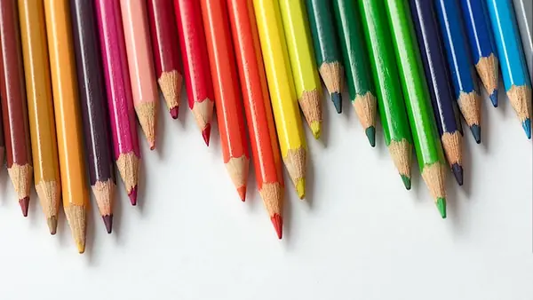 Crayons de couleur alignés en arc-en-ciel sur une feuille blanche