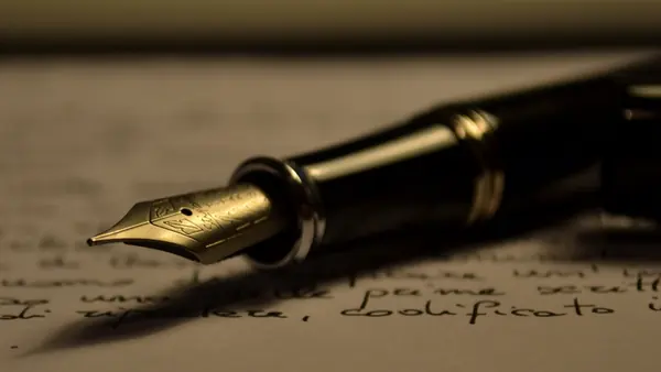 Stylo plume posé sur une page manuscrite