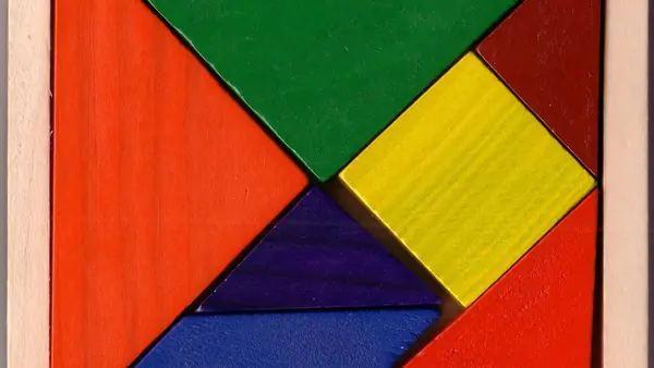 Tangram en bois aux pièces de couleur, rangé dans son cadre