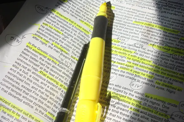 Surligneur jaune posé sur une page de cours surlignée