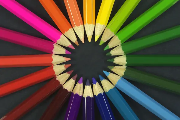Crayons de couleur disposés en cercle, pointes vers le centre